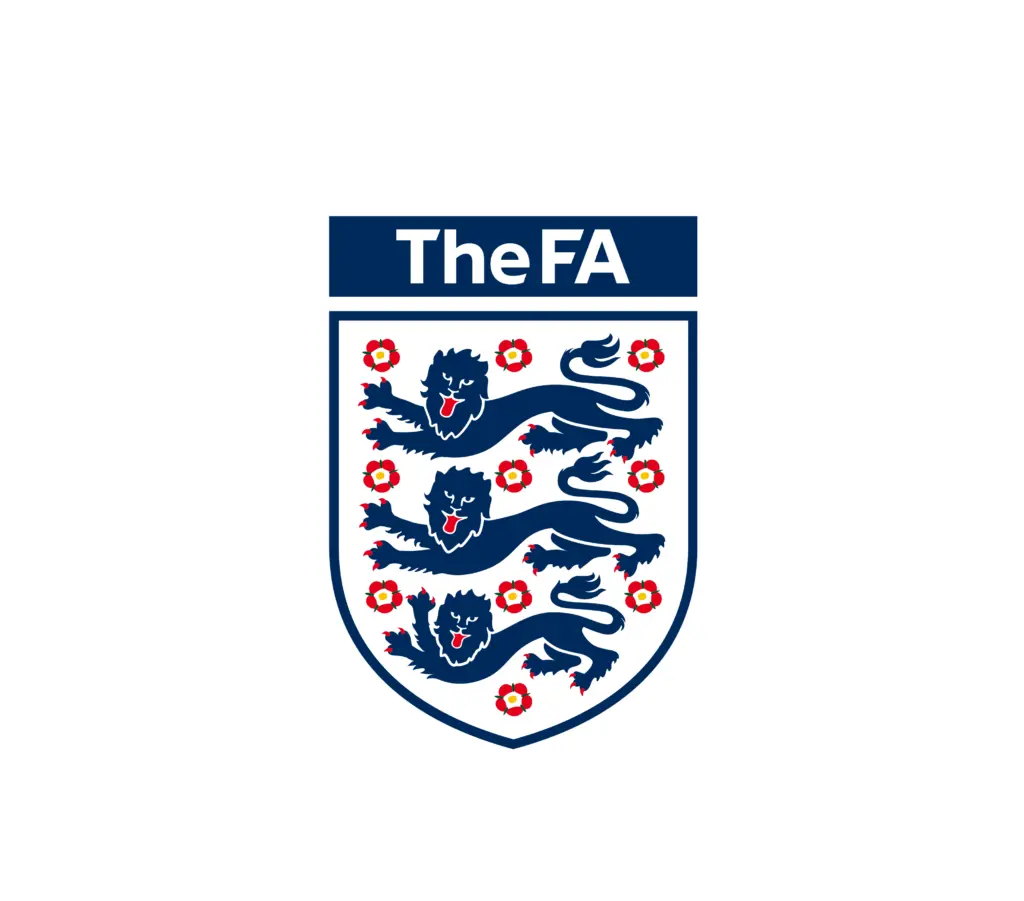 Logo of The FA (The Football Association), featuring a shield with three blue lions and 10 red roses, with the text 'The FA' above the shield in white on a navy blue background.