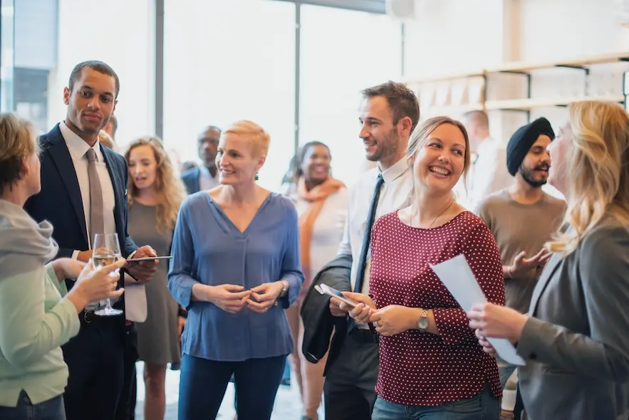 Group of professionally dressed people in conversation. Represents users of VeryConnect's alumni fundraising software