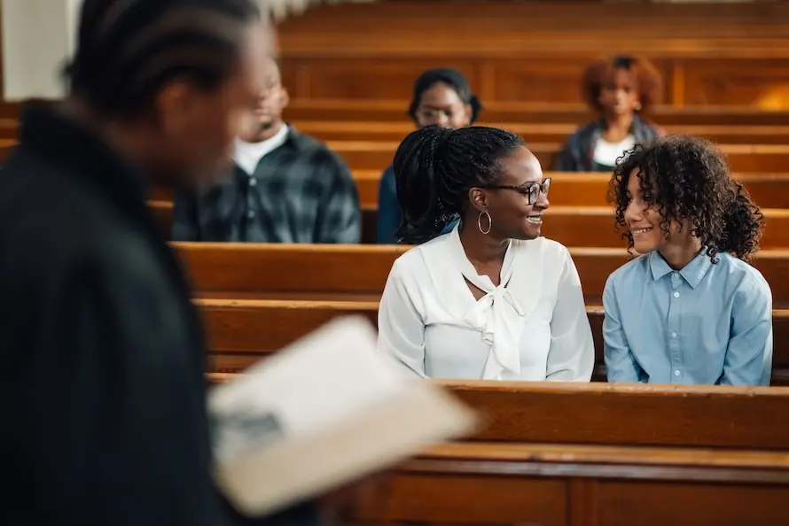 People sitting in church pews looking at each other. Represents users of VeryConnect's church management software.