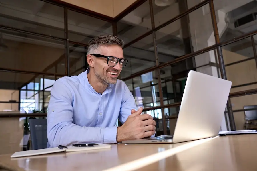 Professional man working on laptop. Represents user of VeryConnect's corporate alumni software.