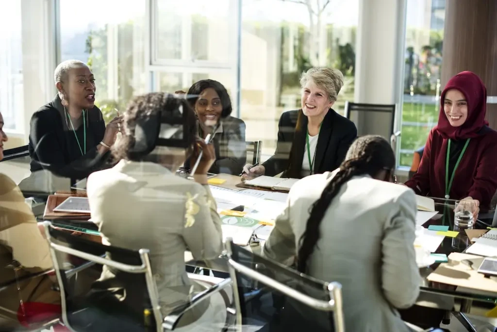 Group of coworkers sitting around meeting table. Represents users of VeryConnect's membership software for small businesses