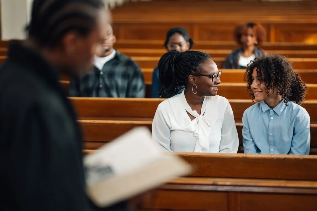 People sitting in church pews looking at each other. Represents users of church management software.