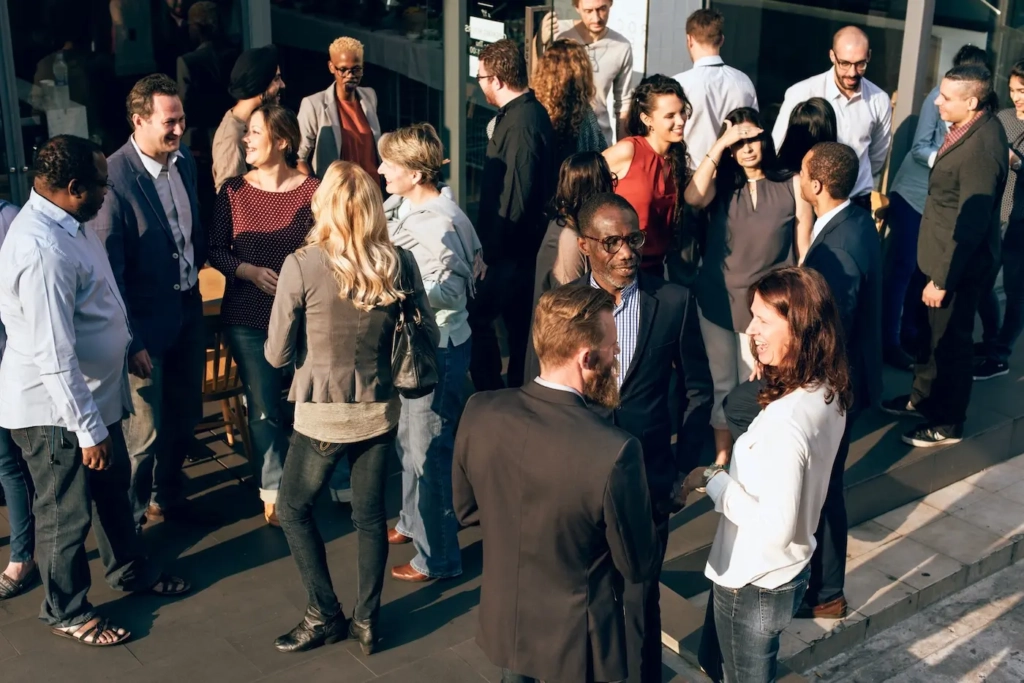 Groups of professionally dressed people, all having conversations. Represents users of VeryConnect's network management software.