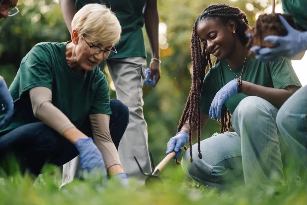 Two women planting a tree. Represents users of VeryConnect's volunteer management software.