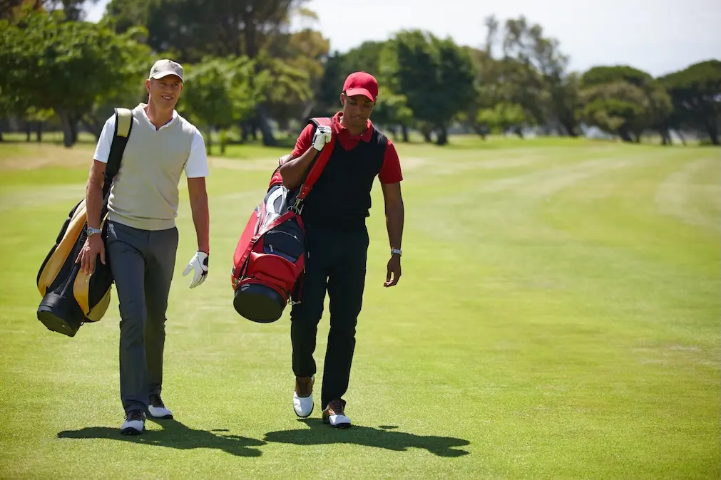 Two golfers walking through field. Represents users of VeryConnect's golf club membership software.