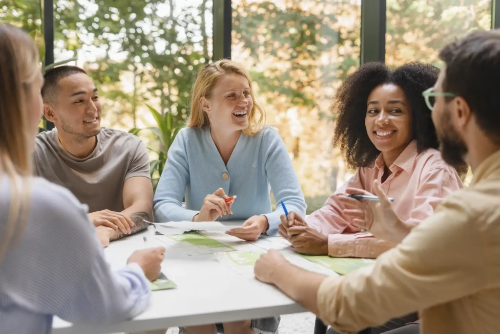 Group of people sat around table in conversation with each other. Represents users of VeryConnect's membership community platform.
